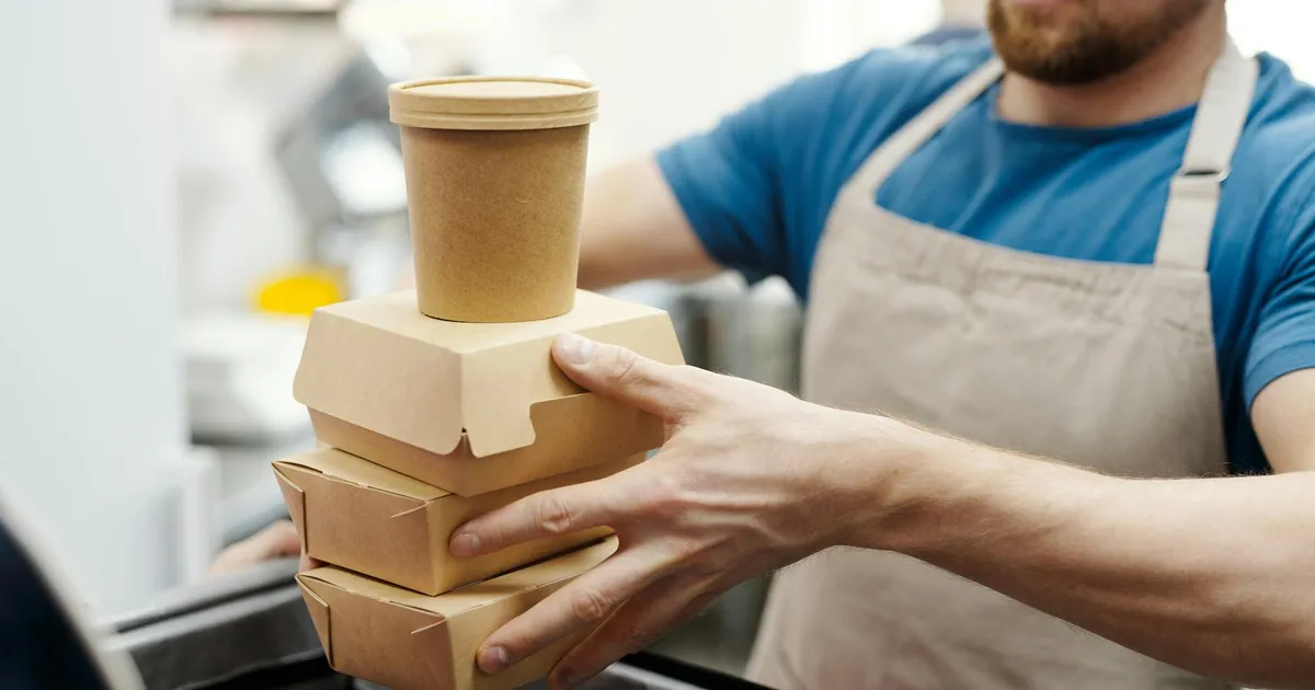 Catering team setting up food service at an outdoor event with proper food holding equipment