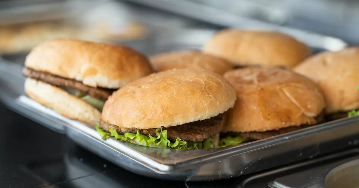 Fast food kitchen staff maintaining organized stations during high-volume service