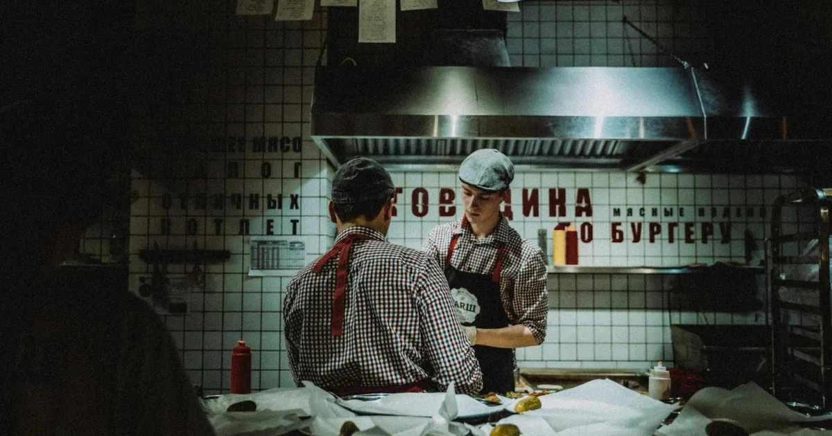 Restaurant kitchen during power outage with staff using flashlights and emergency procedures in progress
