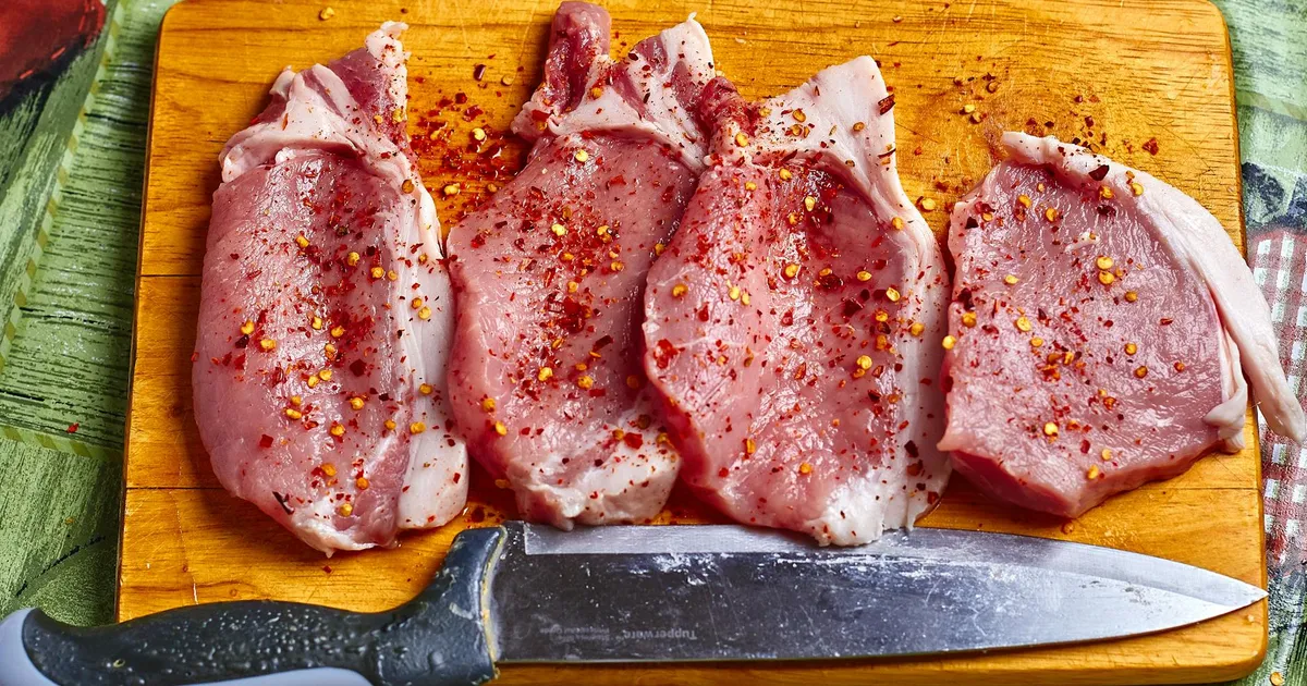 Pork loin being sliced in a commercial kitchen