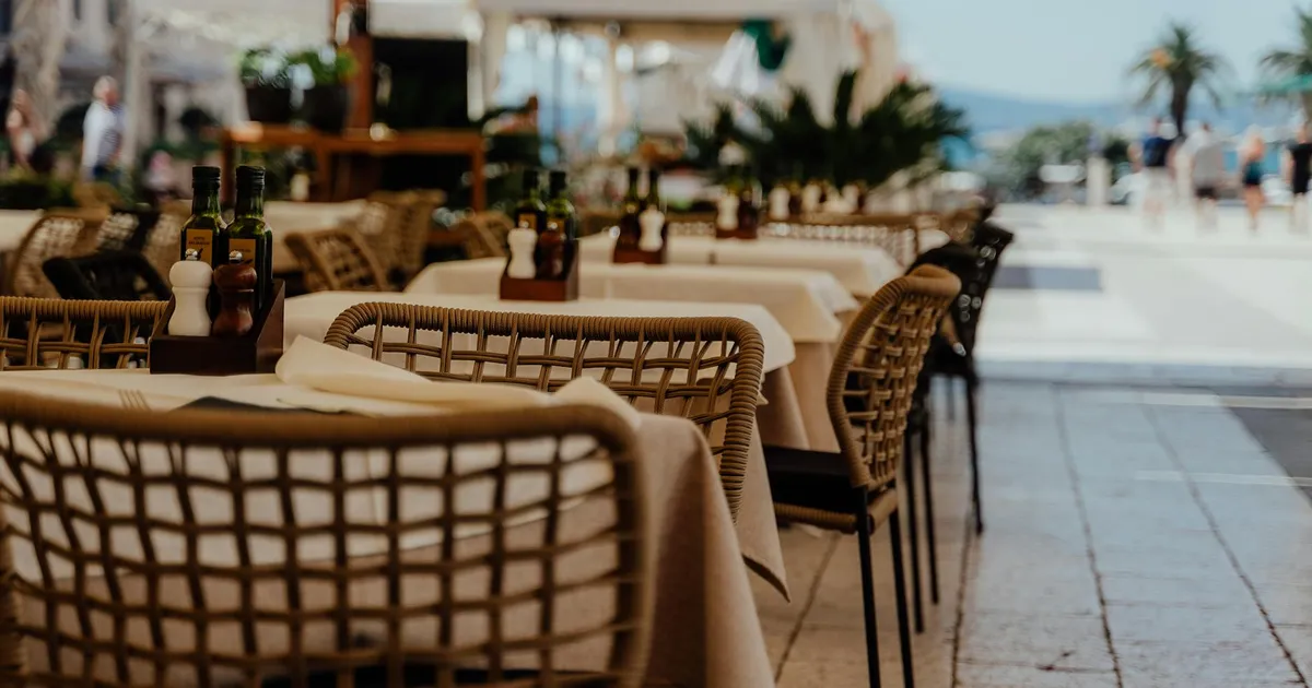 Busy summer restaurant patio with outdoor dining and staff managing food safety in warm weather